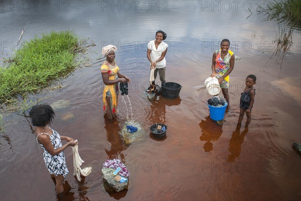 Women washing clothes by the river Ntem in the rainforest