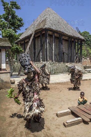 Dancers in traditional clothing wearing carved masks