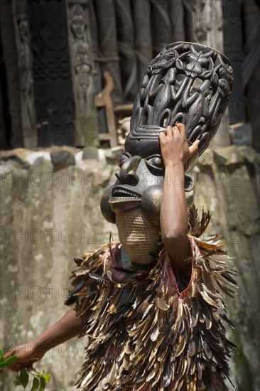 Dancer in traditional clothing wearing carved mask