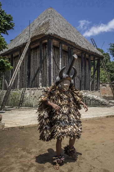 Dancer in traditional clothing wearing carved mask