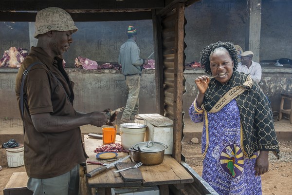 Woman eating grilled meat at street stand