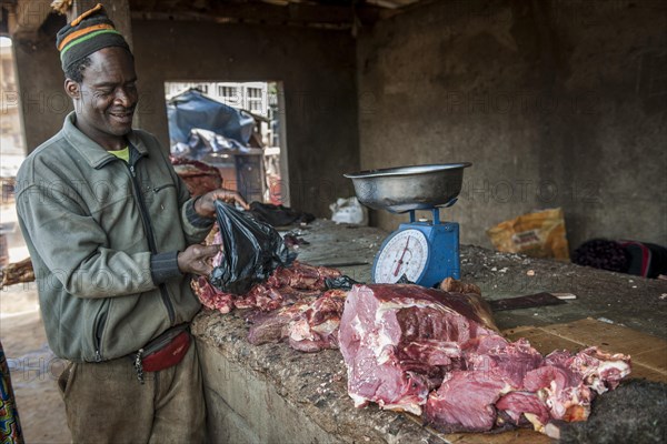 Butcher with meat at market