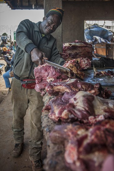 Butcher with meat at market