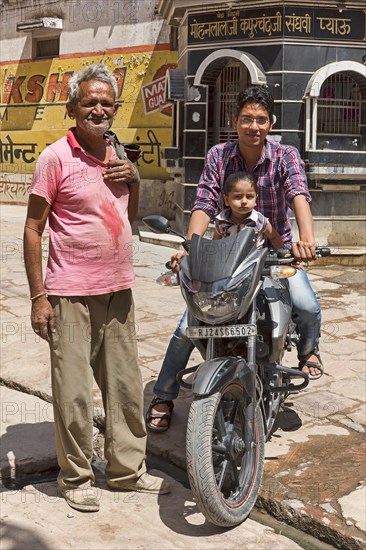Man and child on motorcycle with older man