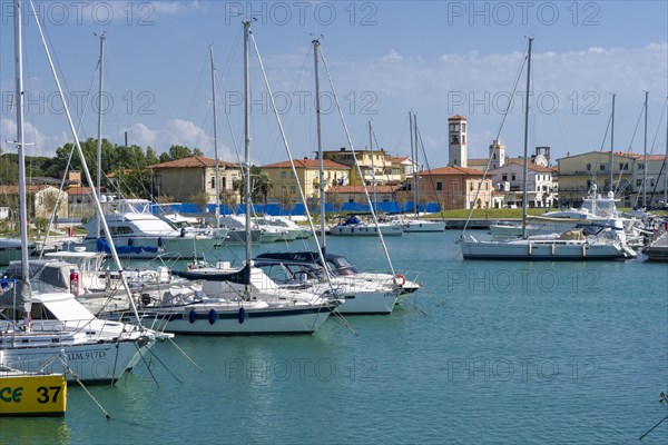 Sailing and motor boats are anchored in the harbour