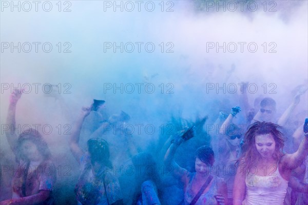 Thousands of young women and man are throwing color powder in the air at the colorful Holi festival