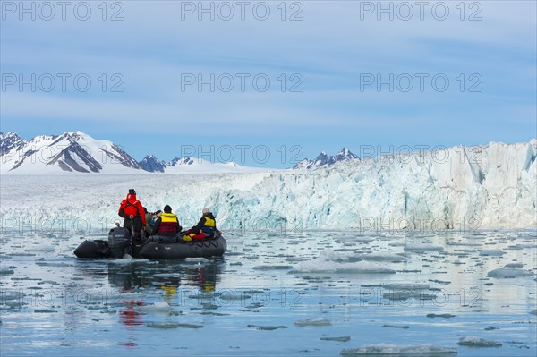 Zodiac boat with tourists navigating in front of Lilliehook glacier