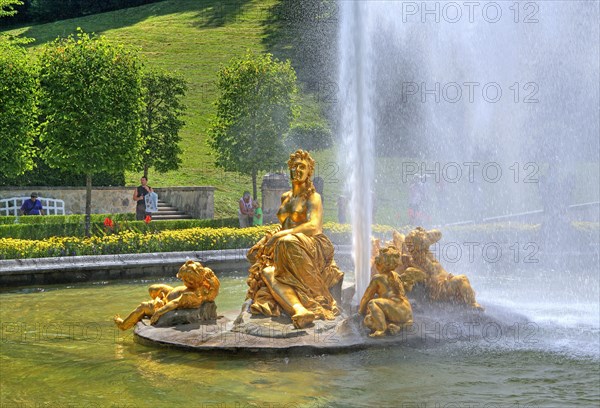 Golden sculpture group with fountain in the basin of the garden parterre