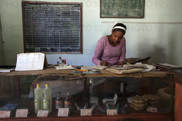 Cuban woman doing accounting in grocery store