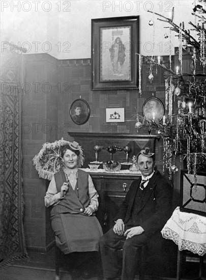 Couple celebrates New Year's Eve in the living room next to the Christmas tree