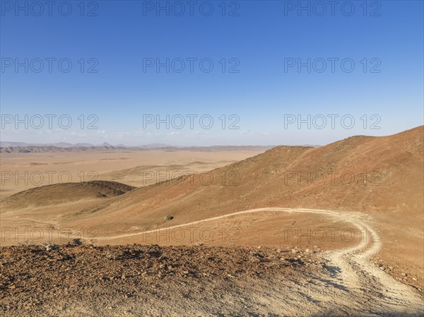 Gravel track through desert landscape