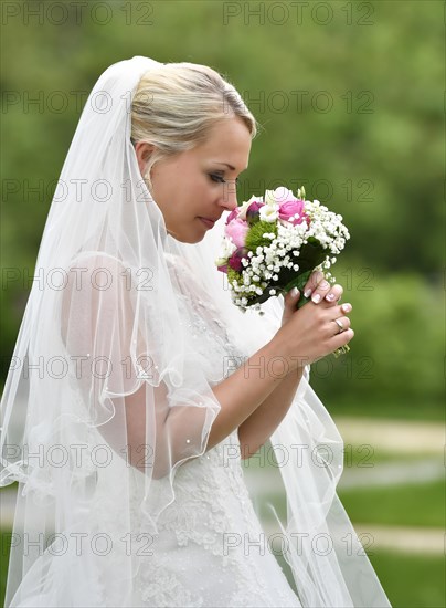 Bride in wedding dress with bridal bouquet and veil