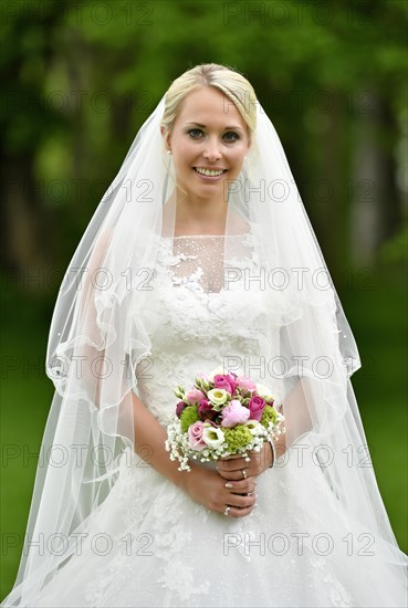 Bride in wedding dress with bridal bouquet and veil