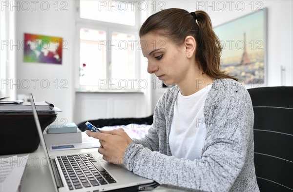 Student with smartphone and laptop