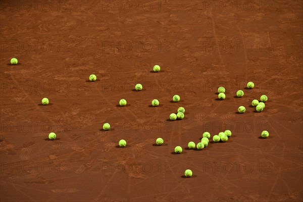 Many tennis balls on clay court