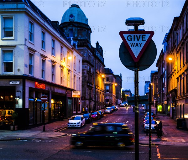 Street at night with driving taxi and road sign