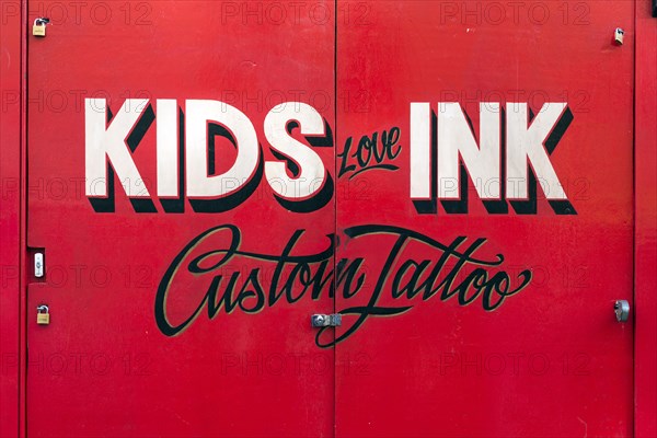 Painted sign for Kids Love Ink tattoo parlor