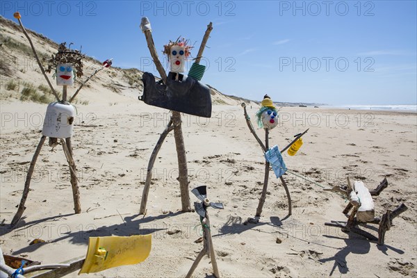 Figures from washed up plastic garbage and flotsam on the sandy beach