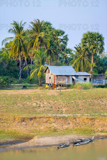 Wooden hut and dugout canoes on the bank of the Stung Sen River