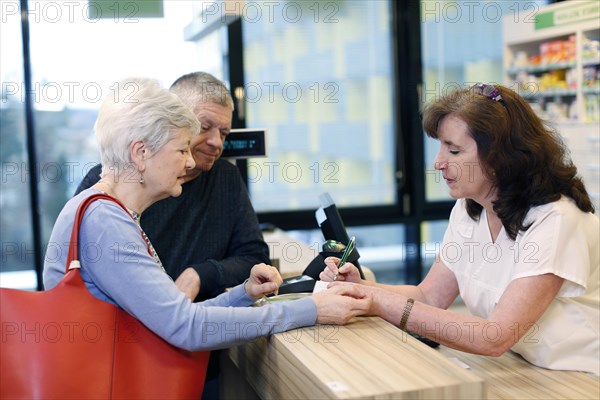 Couple is advised by a pharmacist in a pharmacy