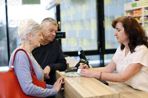 Couple is advised by a pharmacist in a pharmacy