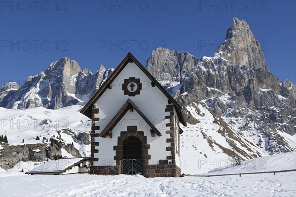 Chapel at the mountain pass Passo Rolle with snow