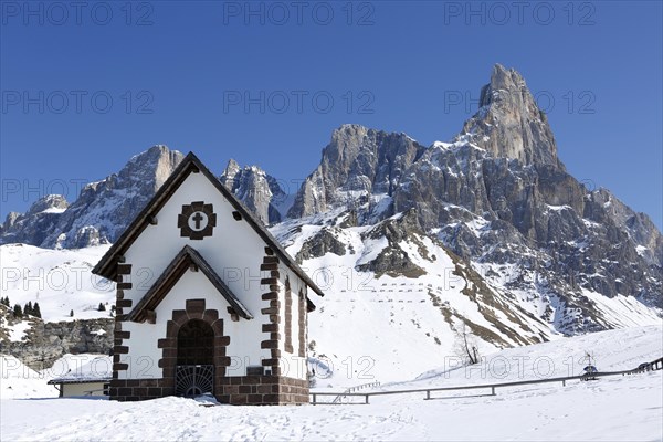 Chapel at the mountain pass Passo Rolle with snow