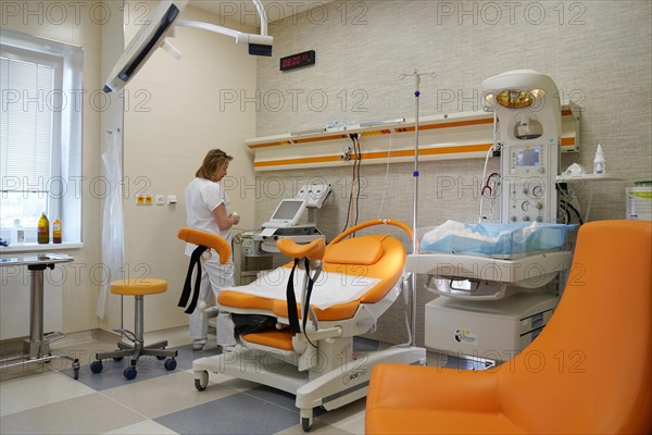 Nurse in an empty modern delivery room with birthing chair