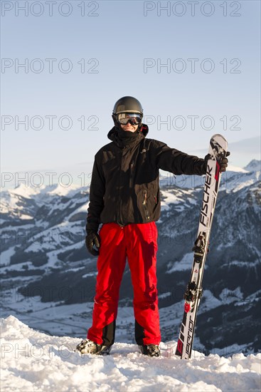 Skier stands at the piste and holds ski