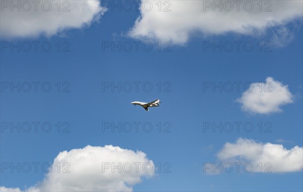 Business Jet flying in front of a blue cloudy sky