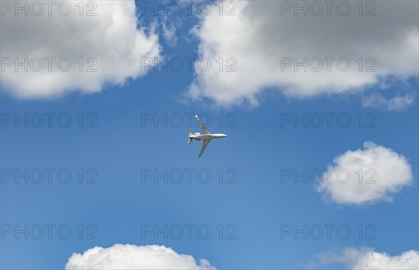 Business Jet flying in front of a blue cloudy sky