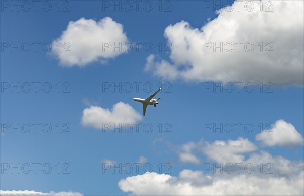 Business Jet flying in front of a blue cloudy sky