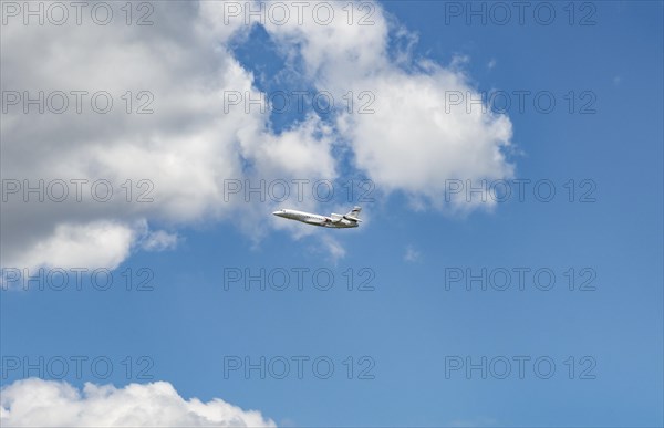 Business Jet flying in front of a blue cloudy sky