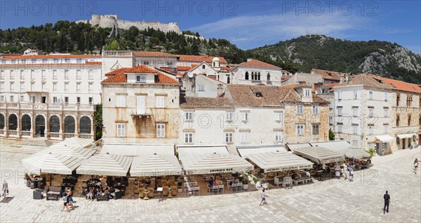 Street cafes at Trg Svetog Stjepana with view to the fortress