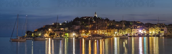 View of the town with sailing boats and lights reflecting in the water