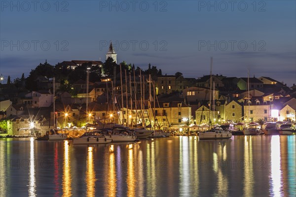 View of the town with sailing boats and lights reflecting in the water