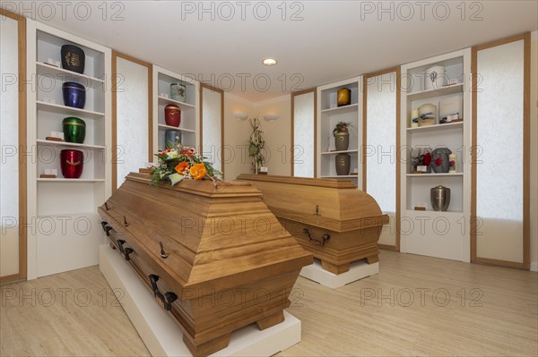 Coffins and urns in the exhibition room of a funeral parlour