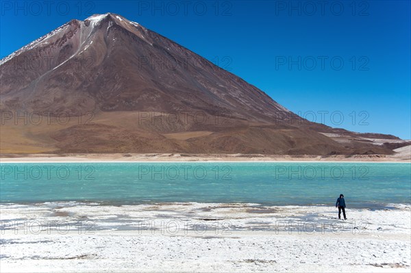 Laguna verde with deposits of borax on the shore and snow on the mountains