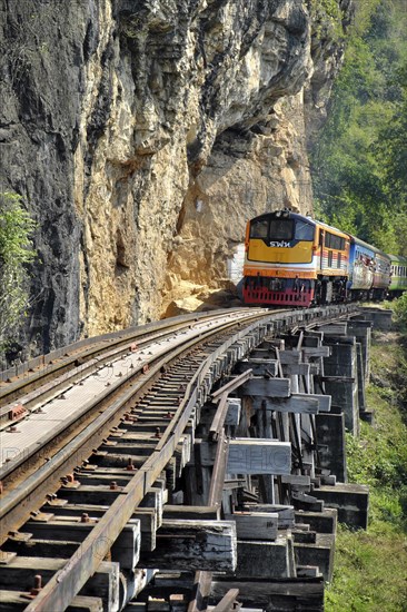 Passenger train runs on wooden bridge