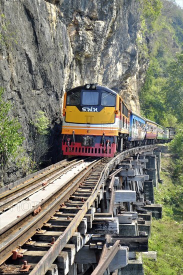 Passenger train runs on wooden bridge