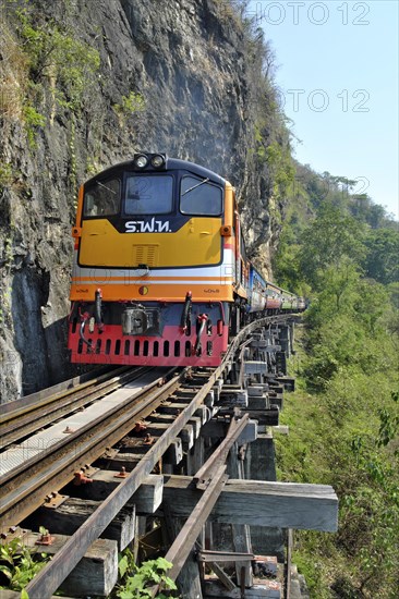 Passenger train runs on wooden bridge