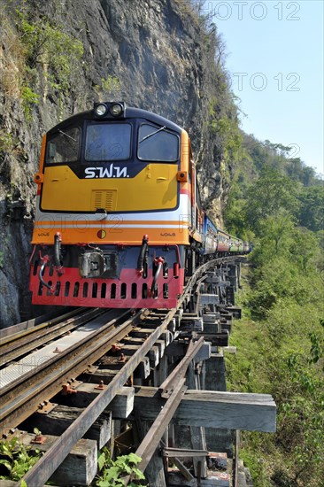 Passenger train runs on wooden bridge