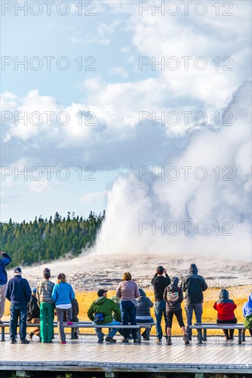 Tourists observe eruption of Old Faithful Geyser