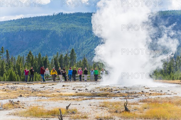 Tourists observe the eruption of the Geyser