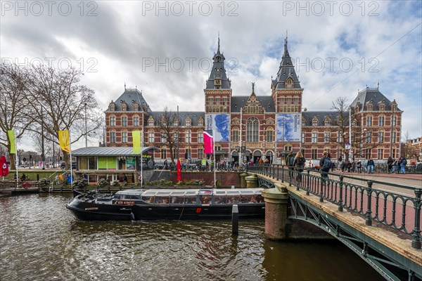 Excursion boat and bridge over Spiegelgracht with Rijksmuseum