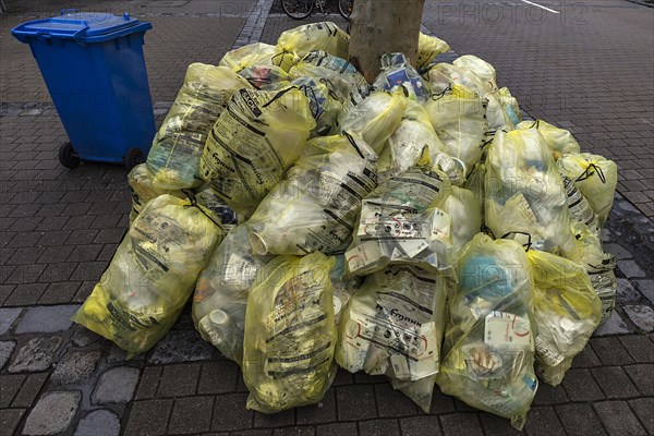 Stacked yellow sacks for waste disposal in the pedestrian zone