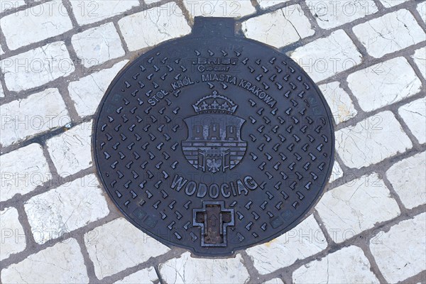 Manhole cover with city coat of arms of Krakow