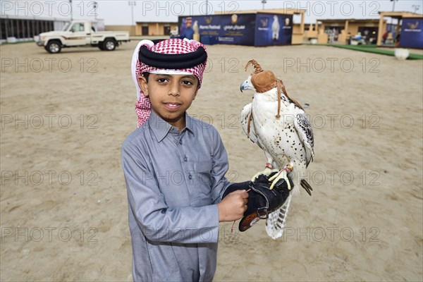 Qatari boy with falcon at Marmi Falcon Festival
