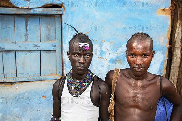 Young men of the Hamer ethnic group with colourful hair clips and pearl jewellery