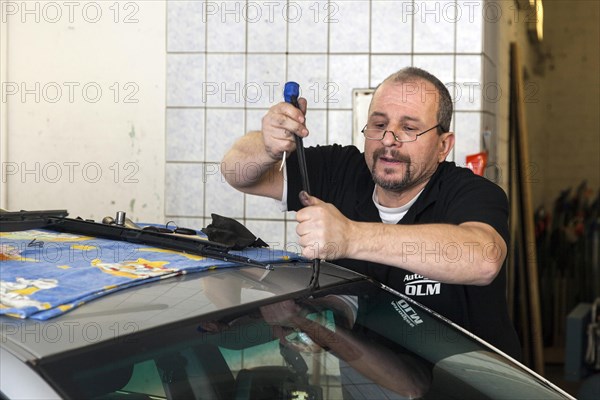 Changing the windscreen of a car in a garage for car glass